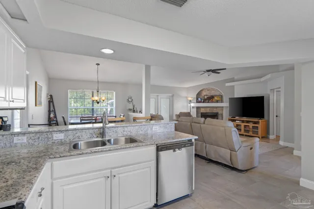 a kitchen with granite countertop a sink and white cabinets