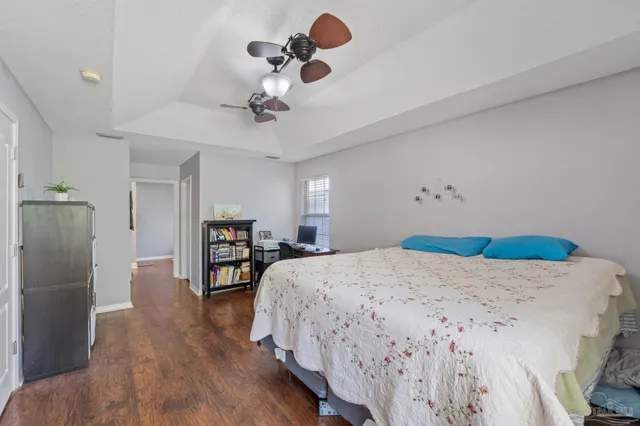 a bedroom with bed and wooden floor