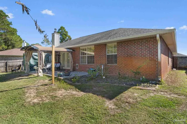 a view of a house with backyard and sitting area