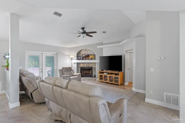 a living room with furniture a fireplace and a flat screen tv