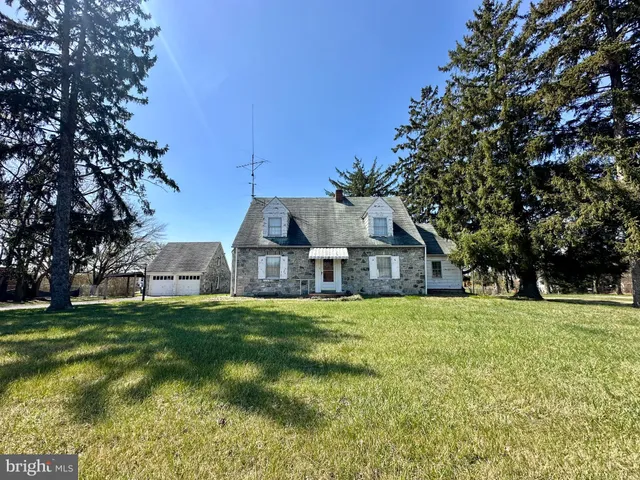 a view of a house with a big yard and large trees
