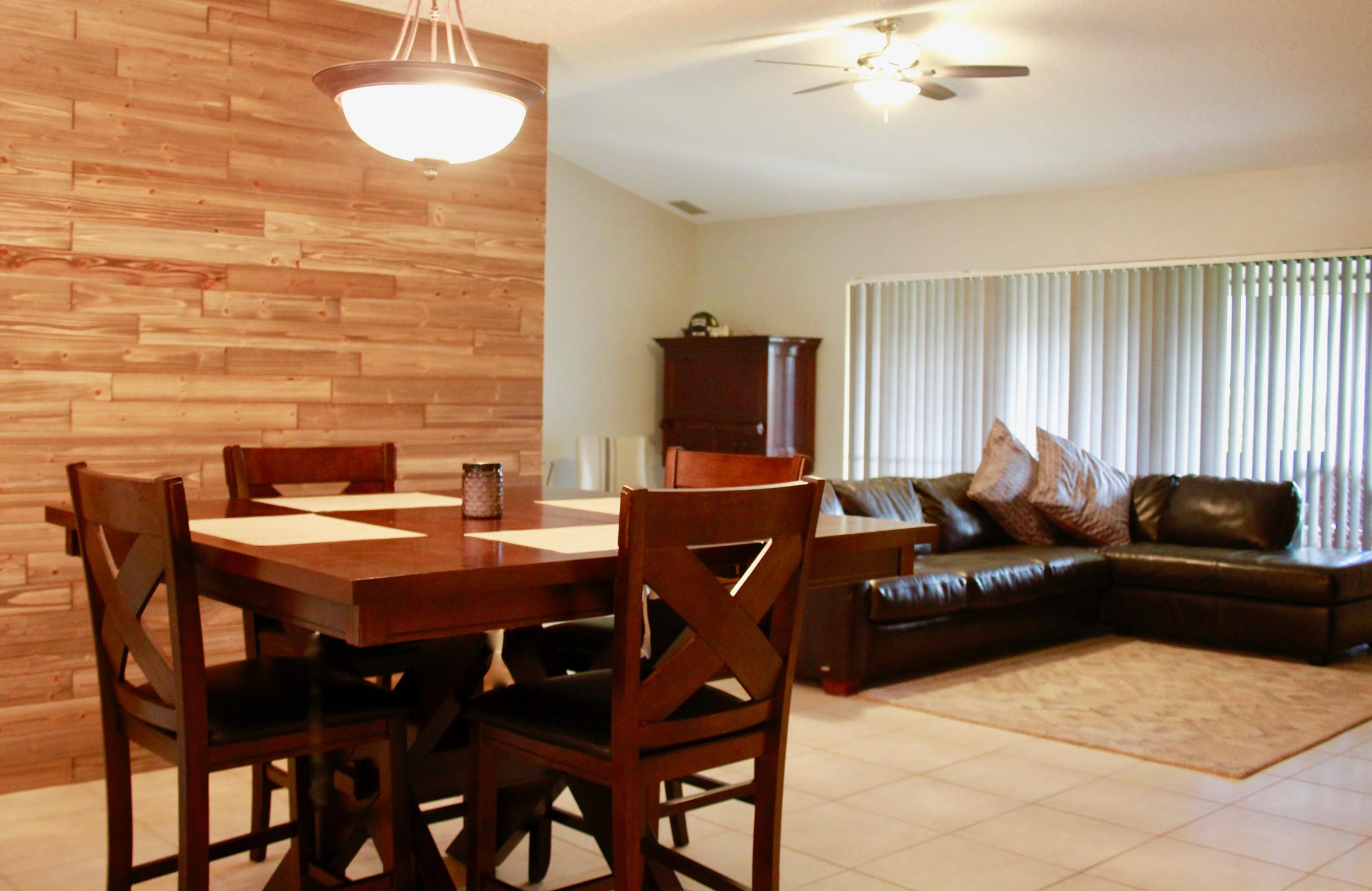 8986 Southwest 19th Street, Unit B Boca Raton, FL 33433 - Photo 13 of 55 a living room with furniture a dining table and a flat screen tv