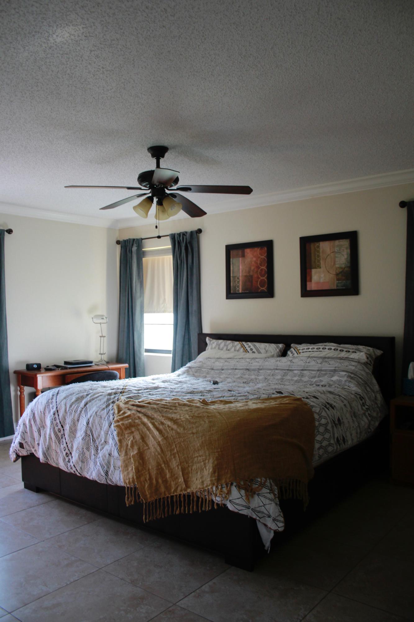 8986 Southwest 19th Street, Unit B Boca Raton, FL 33433 - Photo 24 of 55 a bedroom with a large bed and a chandelier