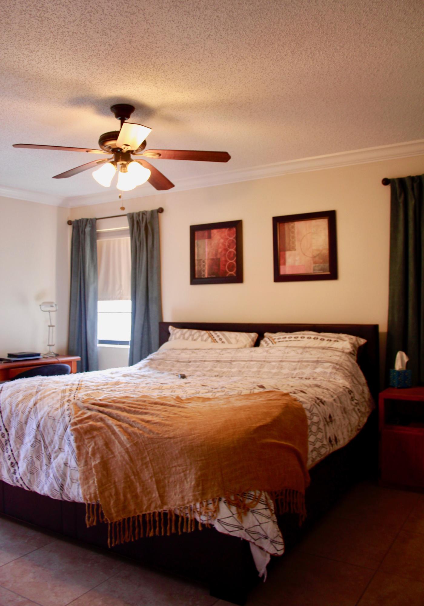 8986 Southwest 19th Street, Unit B Boca Raton, FL 33433 - Photo 25 of 55 a bedroom with a large bed and a chandelier