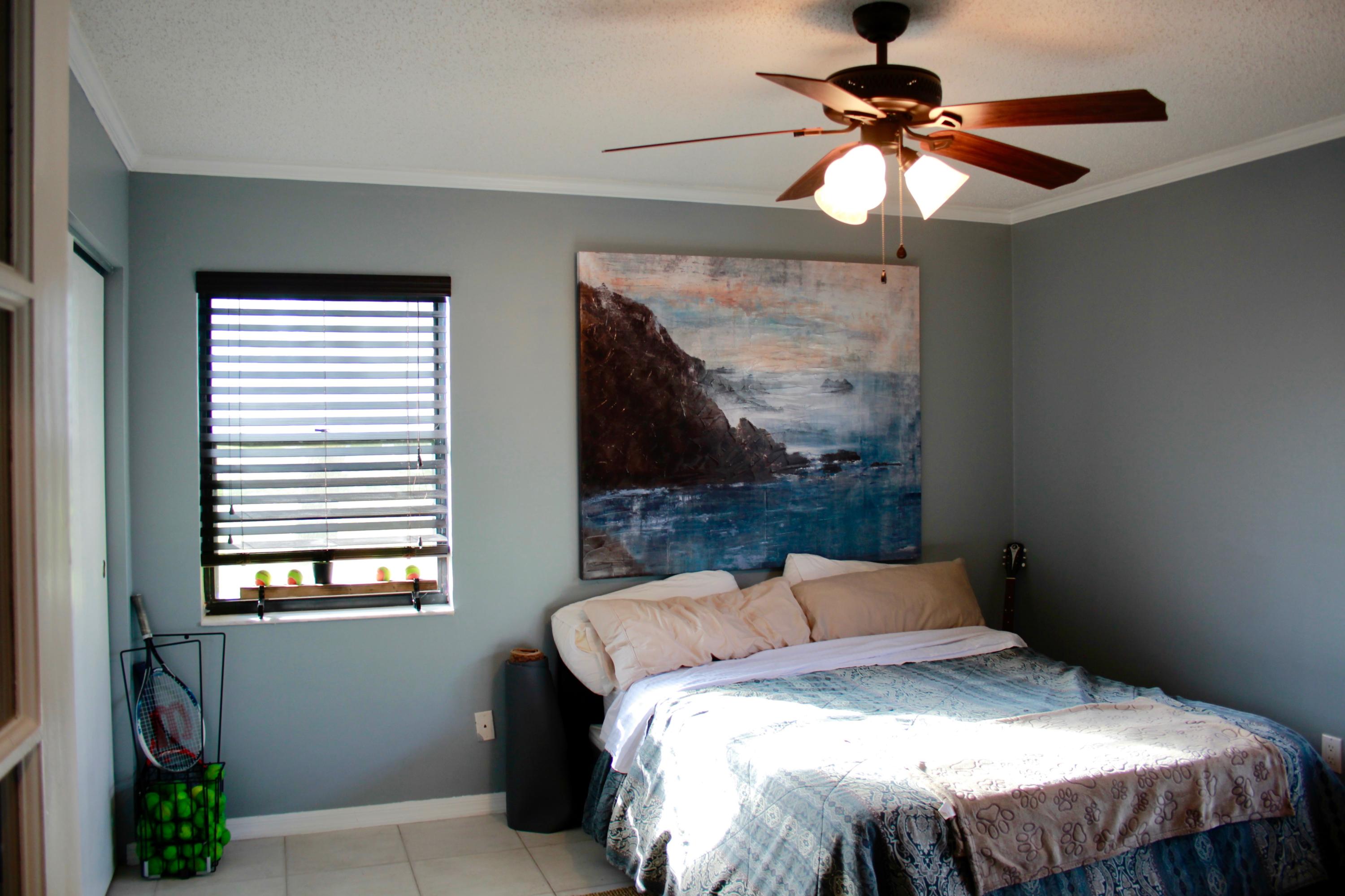 8986 Southwest 19th Street, Unit B Boca Raton, FL 33433 - Photo 32 of 55 a bedroom with a bed and a chandelier