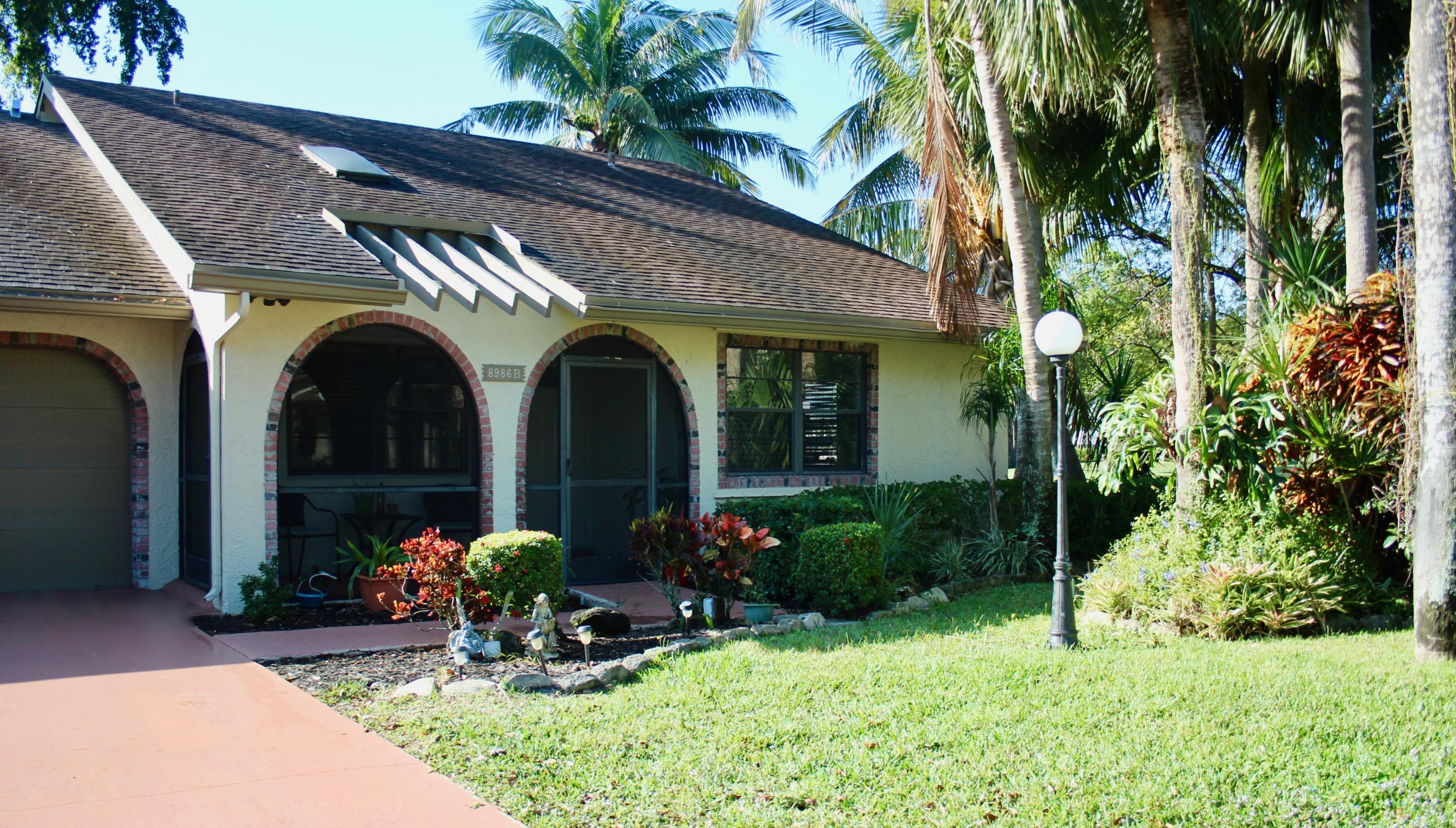 8986 Southwest 19th Street, Unit B Boca Raton, FL 33433 - Photo 45 of 55 a front view of a house with lots of green space