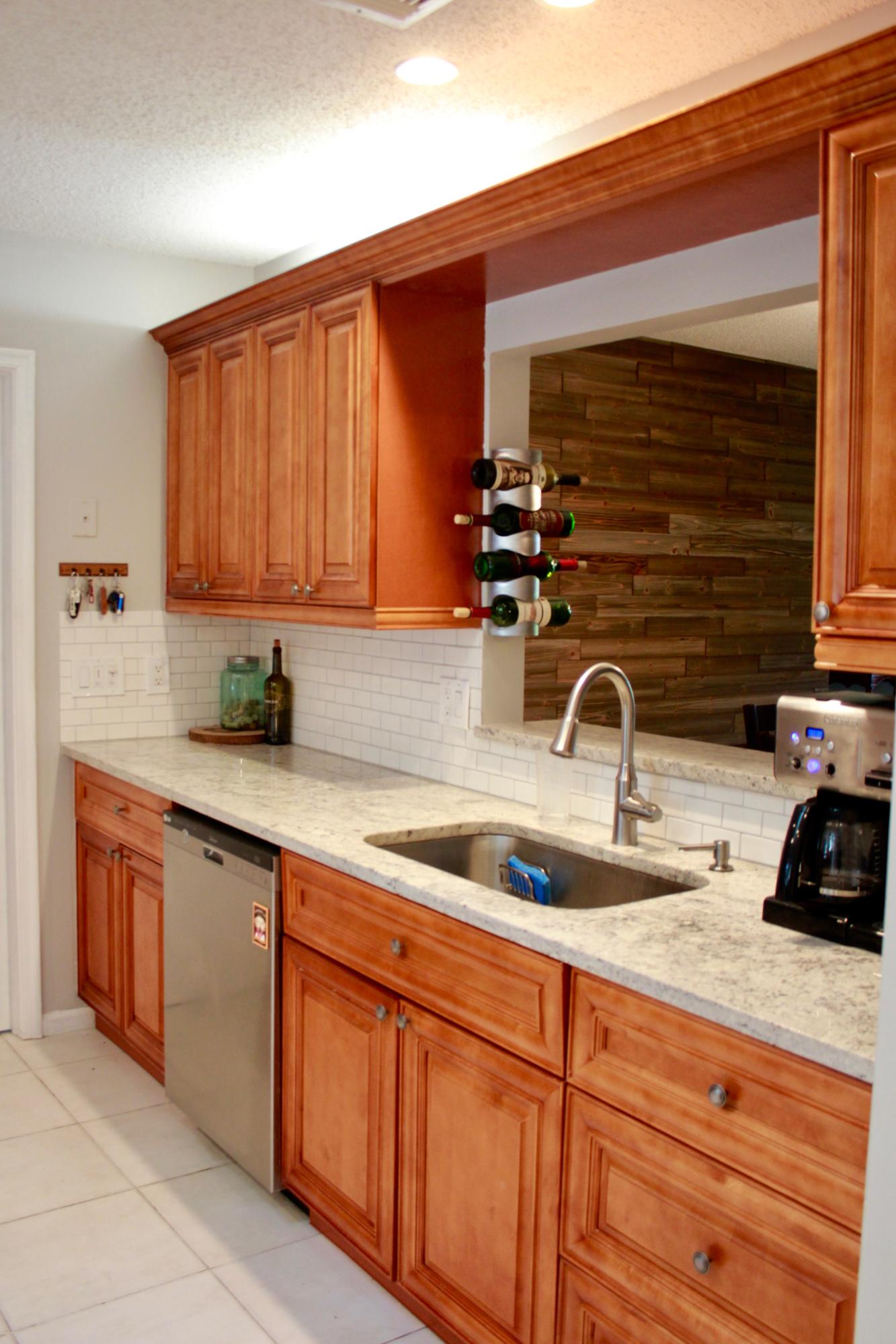 8986 Southwest 19th Street, Unit B Boca Raton, FL 33433 - Photo 5 of 55 a kitchen with stainless steel appliances granite countertop a sink and cabinets with wooden floor