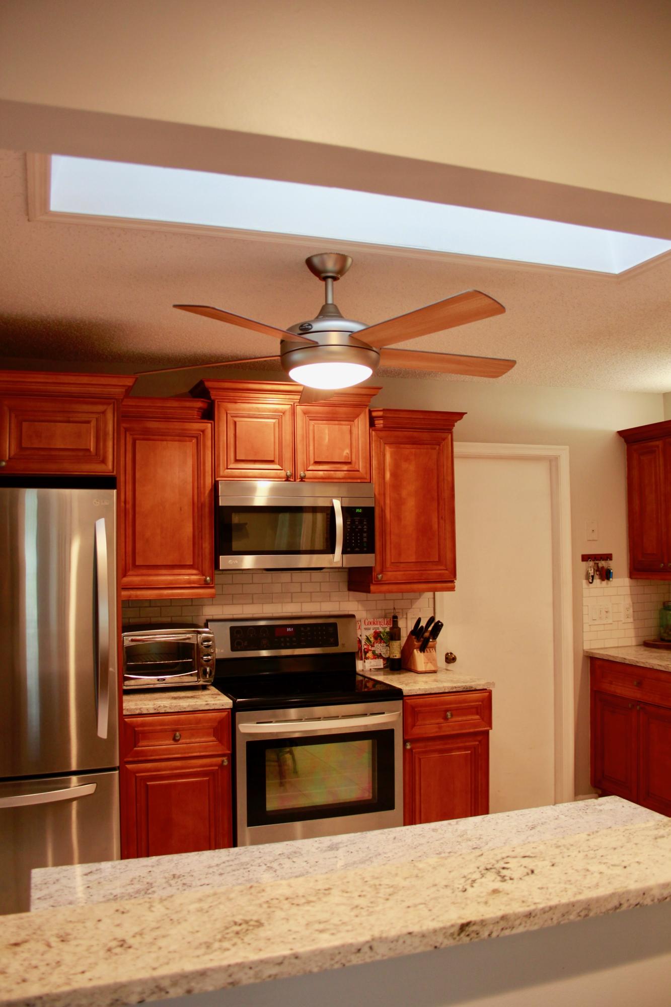 8986 Southwest 19th Street, Unit B Boca Raton, FL 33433 - Photo 9 of 55 a kitchen with stainless steel appliances kitchen island granite countertop a stove and a refrigerator