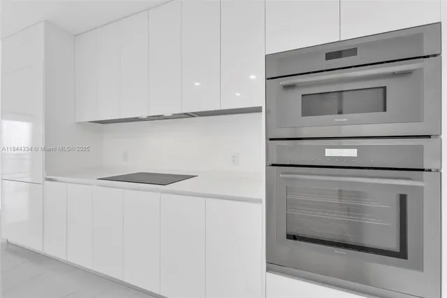 a kitchen with white cabinets and white appliances