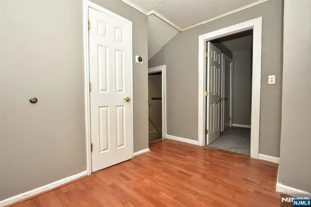 a view of a hallway with wooden floor and closet area