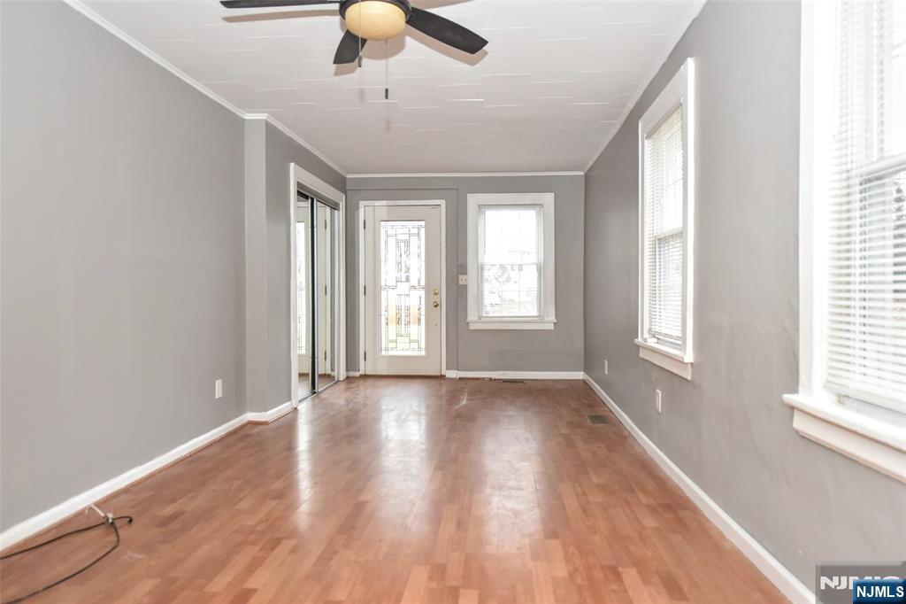 34 Summit Avenue Waldwick, NJ 07463 - Photo 4 of 16 an empty room with wooden floor chandelier fan and windows