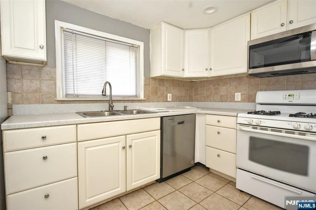 34 Summit Avenue Waldwick, NJ 07463 - Photo 6 of 16 a kitchen with white cabinets appliances and a sink