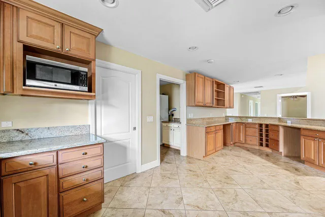a large kitchen with stainless steel appliances granite countertop a large counter top and a stove