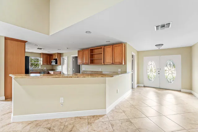 a view of kitchen with stainless steel appliances granite countertop a refrigerator sink and cabinets