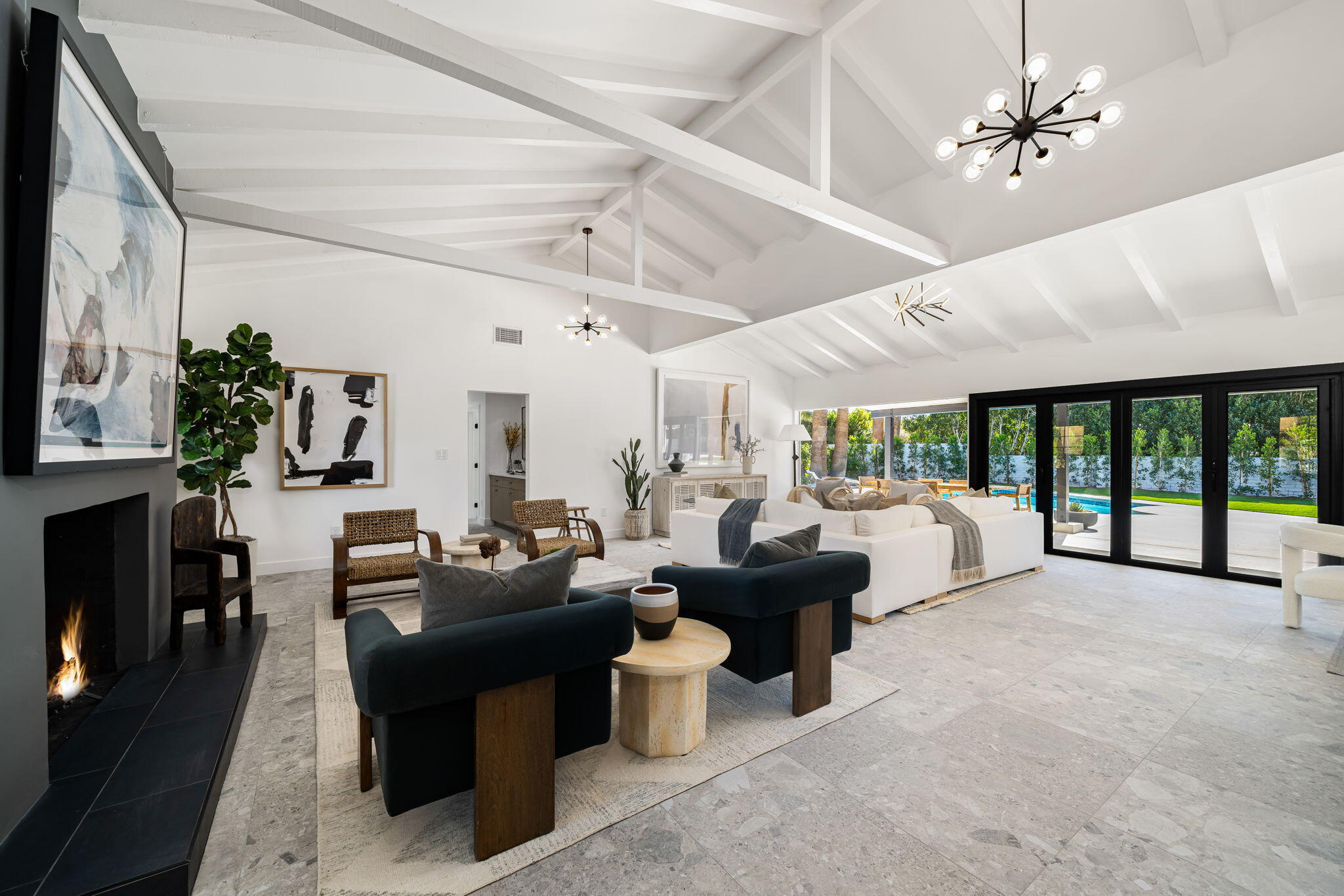 1037 Tamarisk Road Palm Springs, CA 92262 - Photo 5 of 31 a living room with furniture large windows and a fireplace