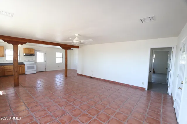 a view of a hallway with wooden floor and a living room
