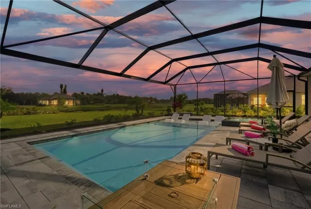 a view of a swimming pool with a couches chairs and a yard