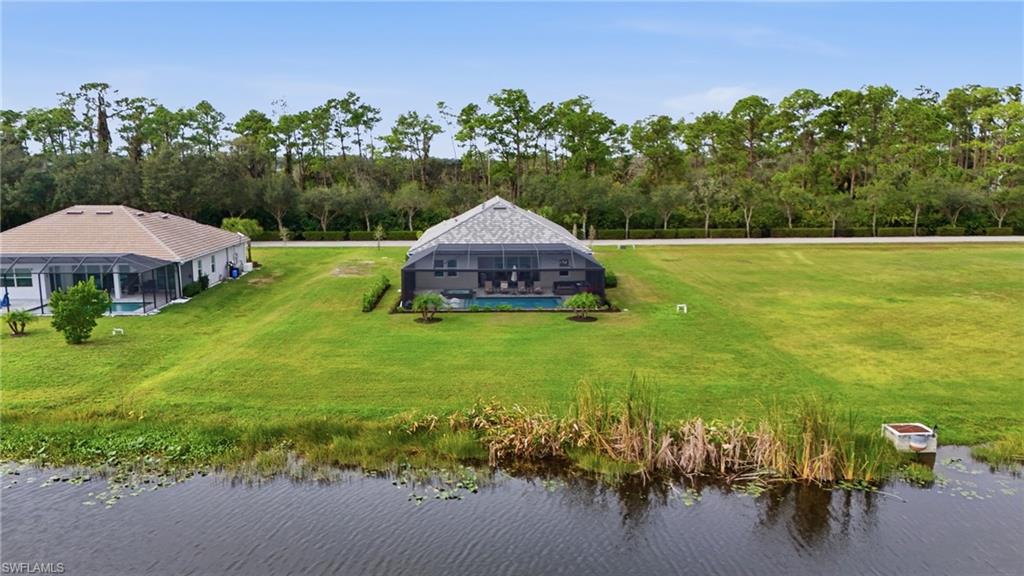 17120 Serengeti Circle Alva, FL 33920 - Photo 46 of 50 a view of a garden with a bench under an umbrella