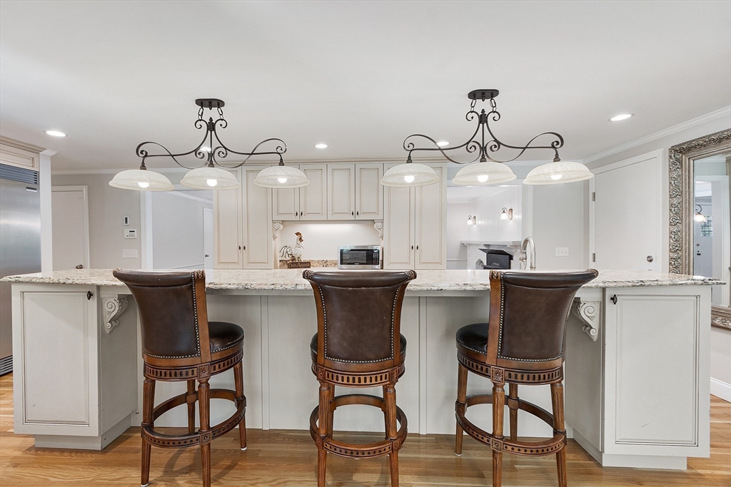 707 Sterling Road Lancaster, MA 01523 - Photo 11 of 40 a kitchen with stainless steel appliances a dining table chairs and white cabinets