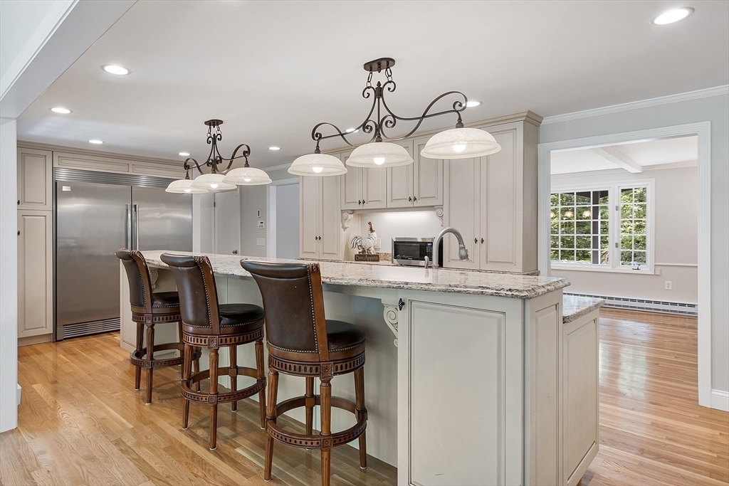 707 Sterling Road Lancaster, MA 01523 - Photo 12 of 40 a kitchen with stainless steel appliances a dining table chairs and wooden floor