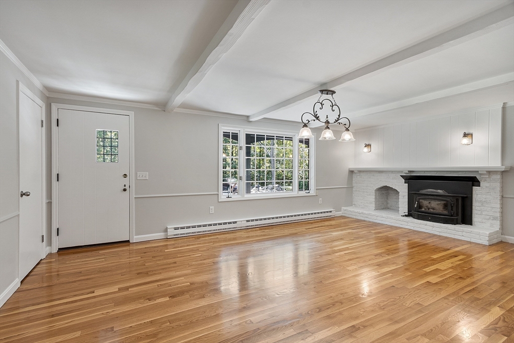 707 Sterling Road Lancaster, MA 01523 - Photo 14 of 40 a view of an empty room with wooden floor fireplace and a window