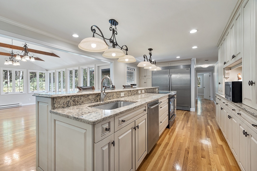 707 Sterling Road Lancaster, MA 01523 - Photo 8 of 40 a large white kitchen with a large island oven a sink stainless steel appliances and cabinets