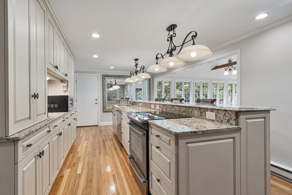 707 Sterling Road Lancaster, MA 01523 - Photo 9 of 40 a kitchen with stainless steel appliances granite countertop a stove and a wooden floors