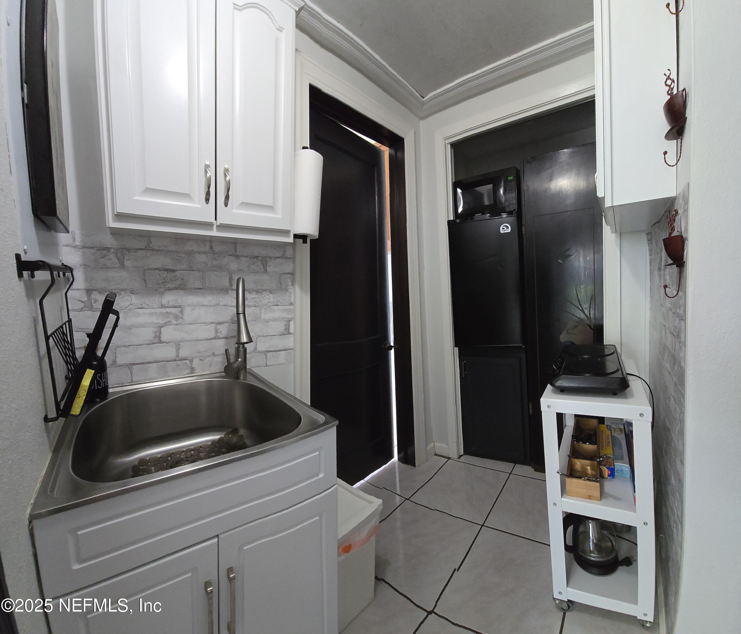 1228 Glen Laura Road Jacksonville, FL 32205 - Photo 21 of 40 a kitchen with a sink and cabinets