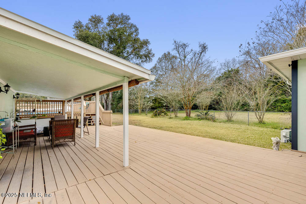 1228 Glen Laura Road Jacksonville, FL 32205 - Photo 25 of 40 a view of a patio with dining table and chairs with wooden floor and fence