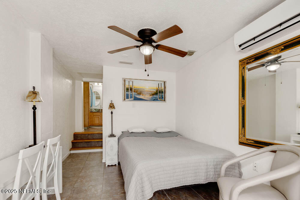 1228 Glen Laura Road Jacksonville, FL 32205 - Photo 30 of 40 a bedroom with a bed and a chandelier