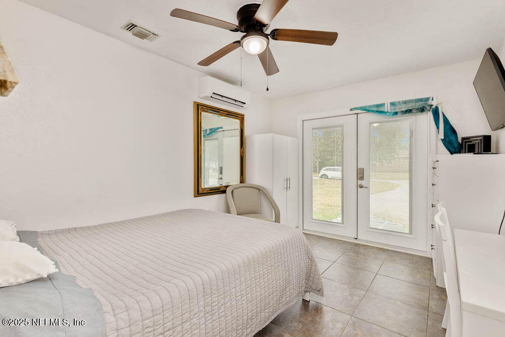 1228 Glen Laura Road Jacksonville, FL 32205 - Photo 31 of 40 a bedroom with a bed and a chandelier