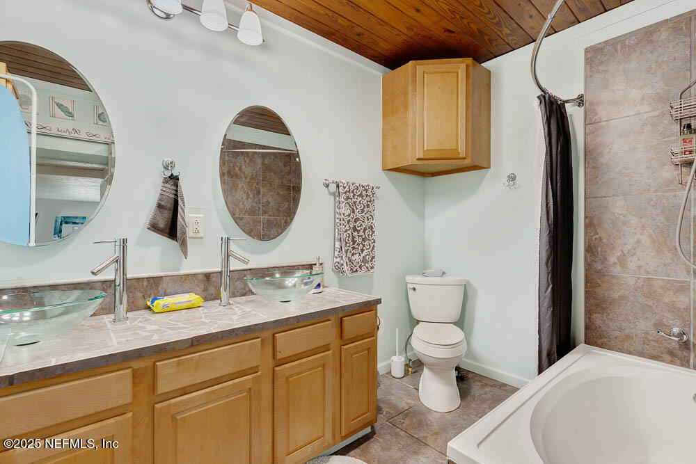 1228 Glen Laura Road Jacksonville, FL 32205 - Photo 33 of 40 a bathroom with a toilet sink and mirror