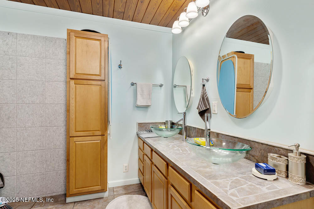 1228 Glen Laura Road Jacksonville, FL 32205 - Photo 34 of 40 a bathroom with a granite countertop sink and a mirror