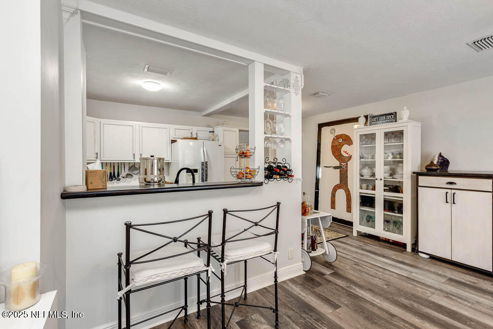1228 Glen Laura Road Jacksonville, FL 32205 - Photo 4 of 40 a kitchen with a table chairs refrigerator and cabinets