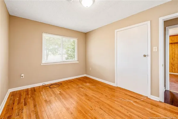 a view of empty room with wooden floor