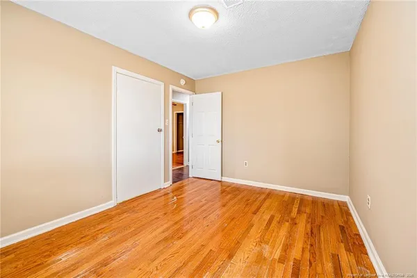a view of a room with wooden floor and a ceiling fan