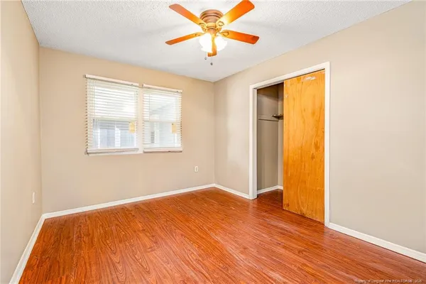 a view of empty room with wooden floor