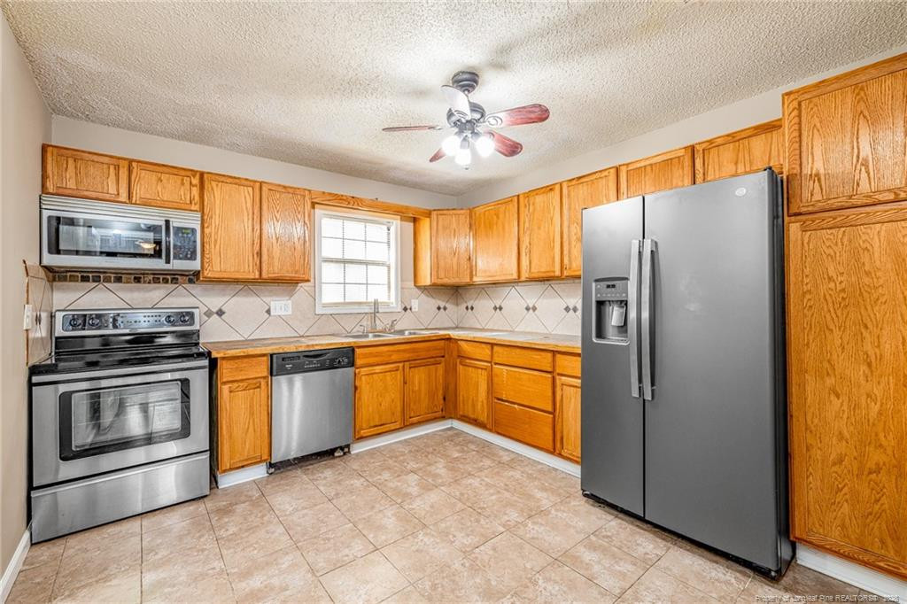 1709 Sandy Run Road Fayetteville, NC 28306 - Photo 9 of 33 a kitchen with stainless steel appliances granite countertop a refrigerator sink and stove