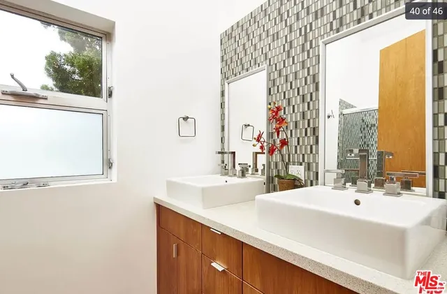 a bathroom with a double vanity sink and a large mirror