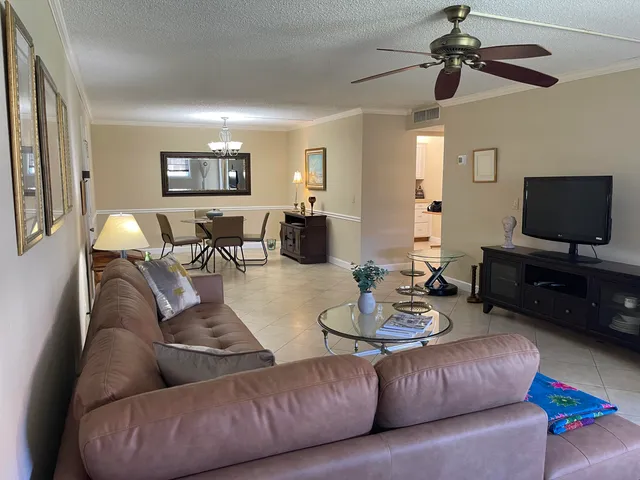 a living room with furniture a flat screen tv and a window