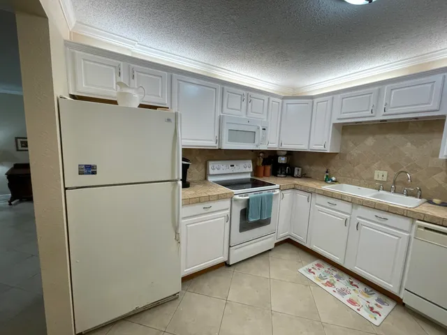 a kitchen with granite countertop white cabinets and sink