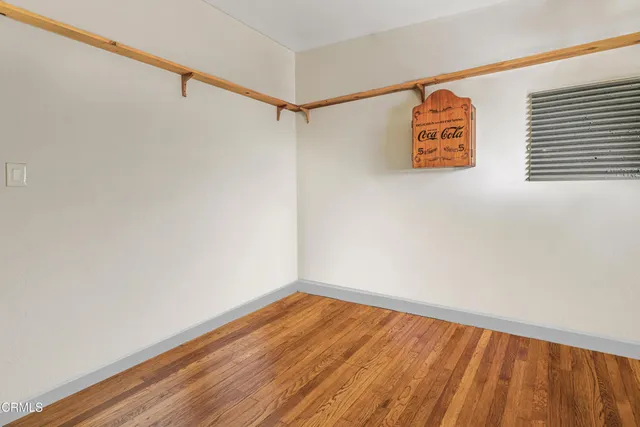 a view of a room with wooden floor and a window