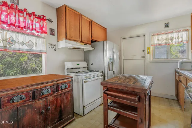 a kitchen with stainless steel appliances granite countertop a stove a refrigerator and a wooden cabinets