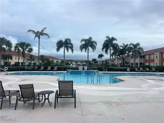 a view of a swimming pool with outdoor seating and plants