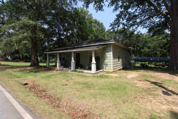 a view of a house with backyard and trees