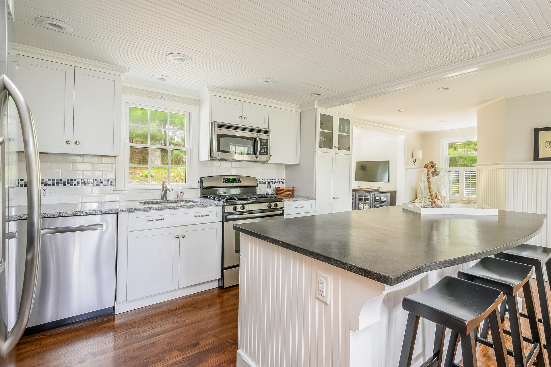 44 Cedarwood Road Cotuit, MA 02635 - Photo 2 of 19 a kitchen with stainless steel appliances granite countertop a stove top oven a sink a refrigerator white cabinets and wooden floor