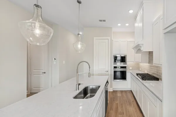 a kitchen with stainless steel appliances granite countertop a refrigerator a sink a stove and a center island
