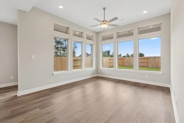 a view of an empty room with a window and wooden floor