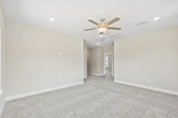 an empty room with a ceiling fan and a window