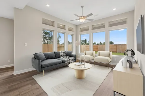 a living room with furniture kitchen view and large windows